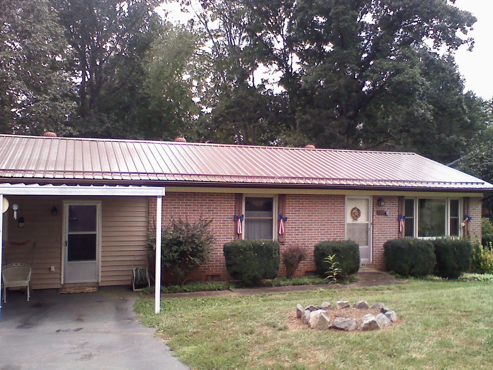 Bronze metal roof and carport on a brick ranch home — Roof Repair work by our crew in Rowlett
