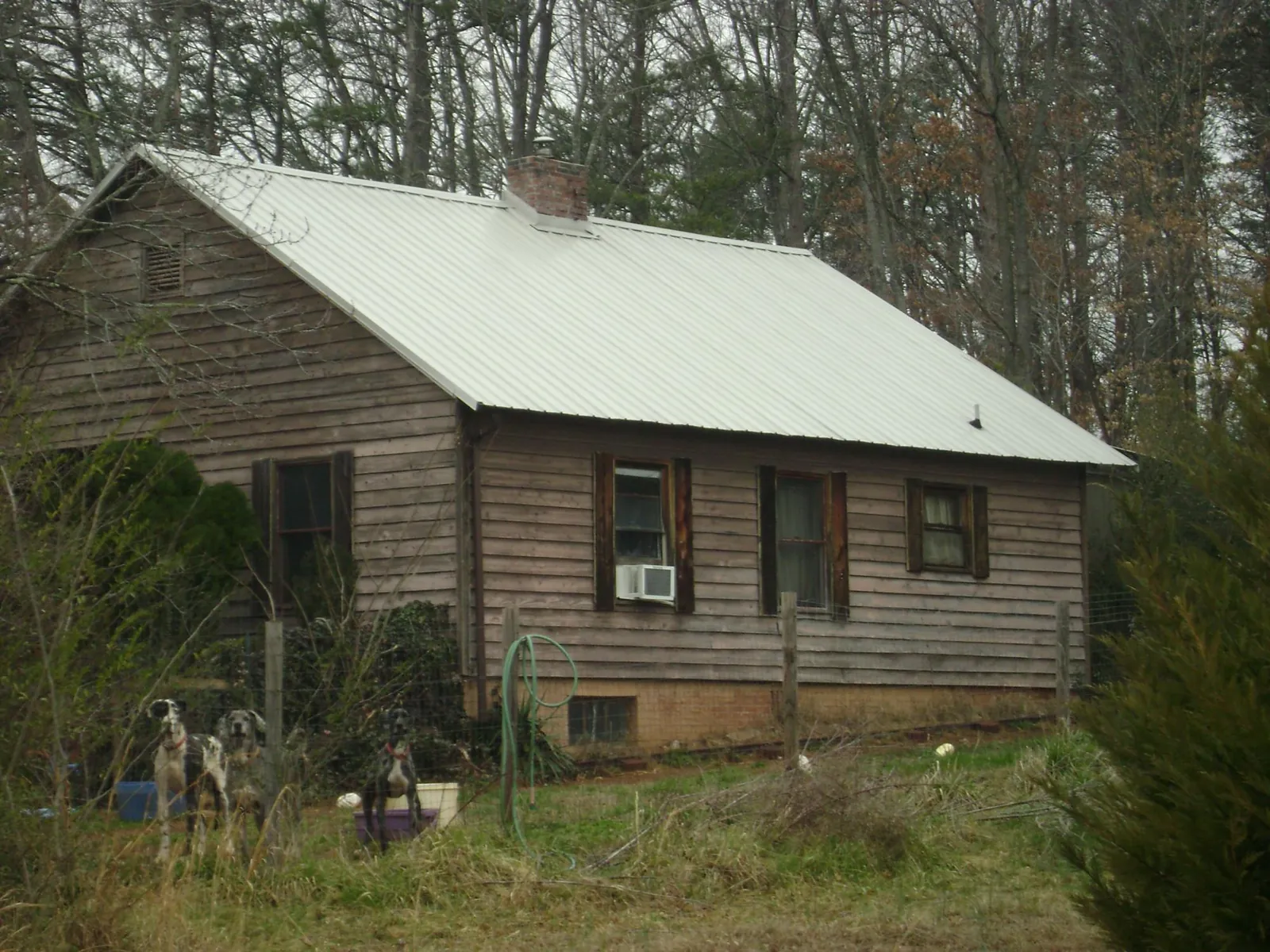 White metal roof on an old wood sided farmhouse, from a Metal Roof Installation job in Rowlett
